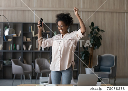 Joyful energetic young african american woman dancing in office. 78038838