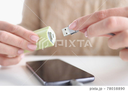 Woman hand inserts usb wire from smartphone into USB flash drive Woman hand inserts usb wire from smartphone into USB flash drive 78038890