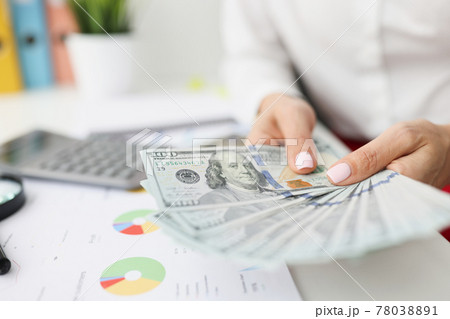 In female hands one hundred dollar bills on table are commercial and financial figures in charts In female hands one hundred dollar bills on table are commercial and financial figures in charts 78038891