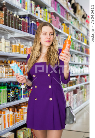 shopper choosing shampoo and balm 78040411