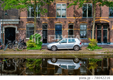 Cars on canal embankment in street of Delft. Delft, Netherlands 78042216