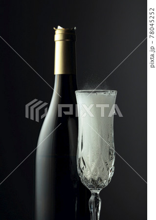 Bottle and glass of champagne on a black background. Bottle and glass of champagne on a black background. 78045252