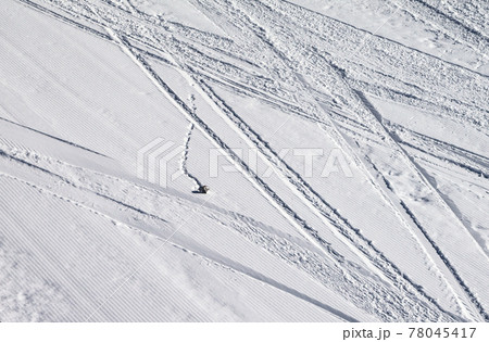 Groomed snowy ski slope with trace from skis, snowboards and stone at winter 78045417