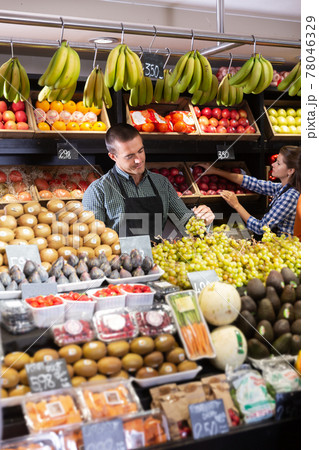 Two sellers laying out vegetables 78046329