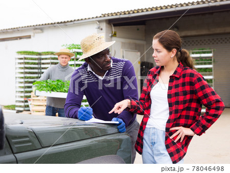 Young girl farmer buying trays with seedlings 78046498