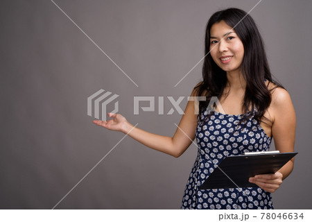 Asian woman wearing blue dress against gray background 78046634