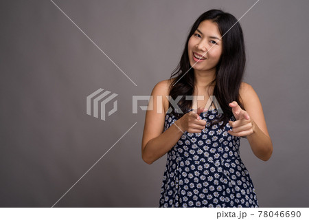 Asian woman wearing blue dress against gray background 78046690