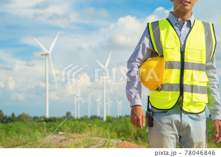 Portrait of Asian windmill engineer man, worker working on site at wind turbines field or farm, renewable clean energy source. Eco technology for electric power. industry nature environment. People 78046846