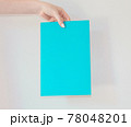 Colored cardboard with an announcement in the hand of a young girl with interesting and important information. card for the inscription. 78048201