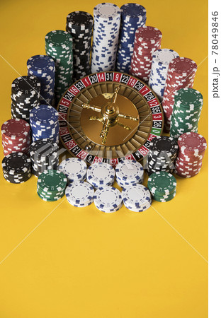 Poker Chips on gaming table, roulette wheel in motion, casino background 78049846
