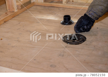 Plumber jointing installing sewage shower drain pipes on a house under construction Plumber jointing installing sewage shower drain pipes on a house under construction 78052150