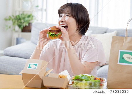 デリバリーで注文した料理を食べる女性 デリバリーで注文した料理を食べる女性 78055056