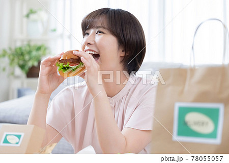 デリバリーで注文した料理を食べる女性 78055057