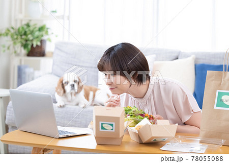 デリバリーで注文した料理を食べる女性 78055088