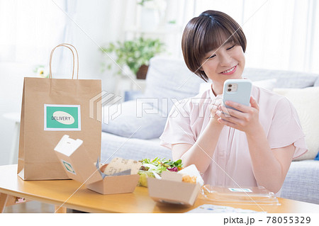 デリバリーで注文した料理を食べる女性 78055329