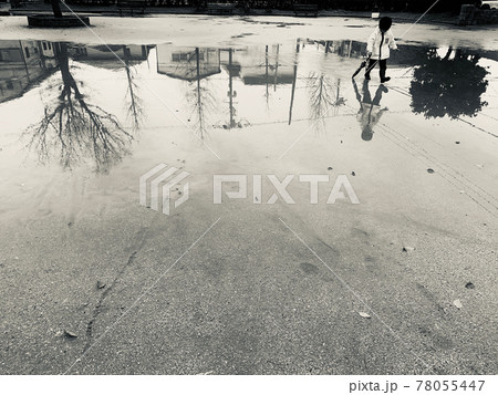 雨の後の大きな水たまりで遊ぶ子供 78055447