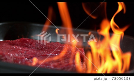 Super slowmotion footage of throwing fresh beef meat and seasoning on ignited pan, 1000fps 4k Super slowmotion footage of throwing fresh beef meat and seasoning on ignited pan, 1000fps 4k 78056133