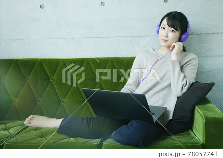 Asian woman sitting sofa. operating a cell phone 78057741