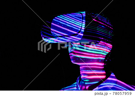 Young woman using virtual reality headset at dark interactive VR exhibition 78057959