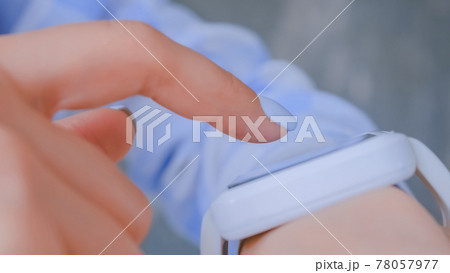 Woman hands using wearable white smart watch device - close up side view 78057977