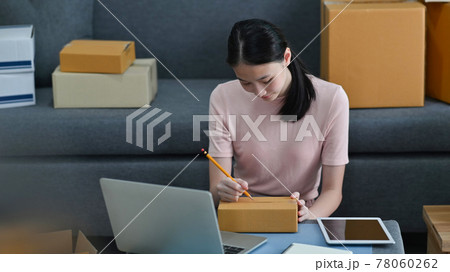 Young business owner writing costumer address on box with selling online concept. 78060262
