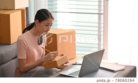 Owner online business writing costumer address on box. SME business startup and online market concept. Owner online business writing costumer address on box. SME business startup and online market concept. 78060264