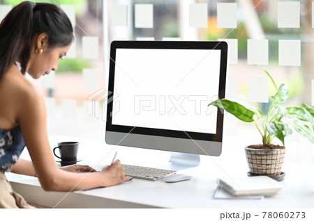 Young creative female working with tablet and white screen computer on office desk. Young creative female working with tablet and white screen computer on office desk. 78060273