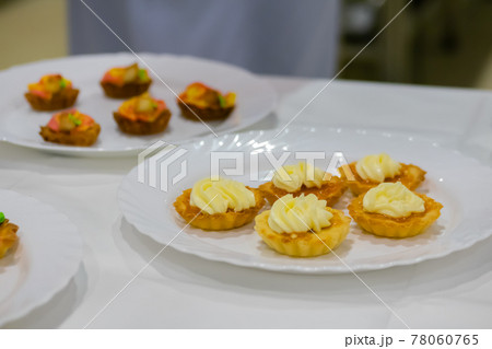 Fresh shortcrust tart cakes with cream on white plate for sale 78060765