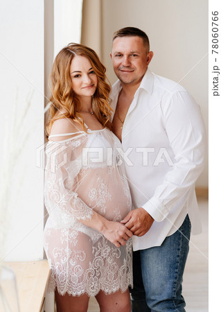 a man and a woman in white waiting for the birth of a child against the wall 78060766