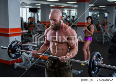 Bald man with a beard in the gym. Muscular bodybuilder guy doing barbell exercises. Strong man with a naked torso. The young athlete is preparing for weightlifting competitions. Bald man with a beard in the gym. Muscular bodybuilder guy doing barbell exercises. Strong man with a naked torso. The young athlete is preparing for weightlifting competitions. 78060852