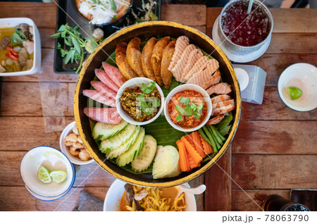 Set appetizer of Northern Thai Food with fried pork, sausage, vegetables and thai chili sauce dip on Khantoke or traditional container 78063790