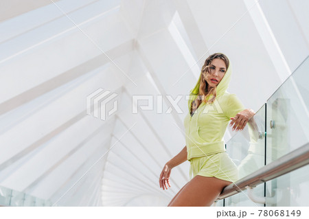 Portrait of a young athletic woman leaning on the railing and looking into the distance. Portrait of a young athletic woman leaning on the railing and looking into the distance. 78068149