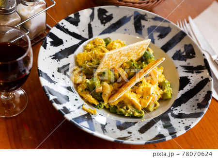 Scrambled eggs with asparagus and prawns at plate 78070624