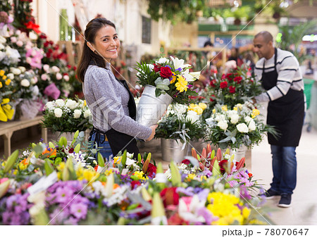 Florist in an apron creates bouquets in flower shop 78070647