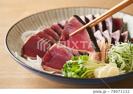 大皿に盛り付けた鰹のたたき 78071132