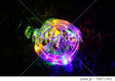 Festive card with bright colorful garland lights in glass jar on night nature background 78071401