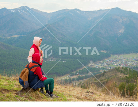 Young traveler couple resting in the mountains. Man and woman hiking with backpacks on a beautiful rocky trail. Family local travel and adventure concept Young traveler couple resting in the mountains. Man and woman hiking with backpacks on a beautiful rocky trail. Family local travel and adventure concept 78072220