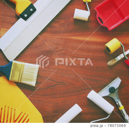 Synthetic brushes, foam rollers, spatulas and other tools for home repair on wooden background. Synthetic brushes, foam rollers, spatulas and other tools for home repair on wooden background. 78073069