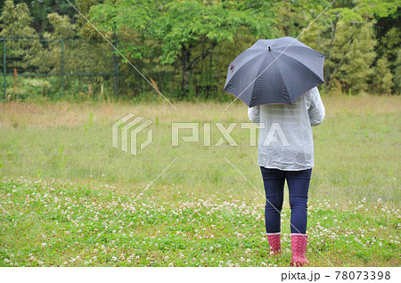 雨の中傘をさし長靴を履いて歩く 雨の中傘をさし長靴を履いて歩く 78073398