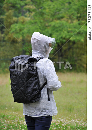 雨の中バックパックにカバーをかけるの写真素材