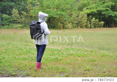 雨の中バックパックにカバーをかけるの写真素材