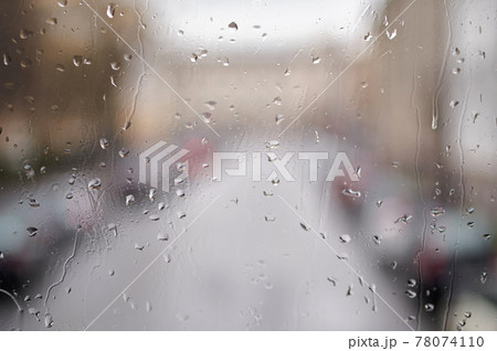 Raindrops on the glass. Blurred urban landscape through the window in the rain, rainy weather. 78074110