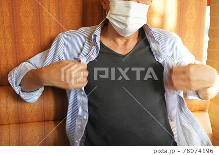 マスクをしながらシャツを扇ぐミドル男性 78074196