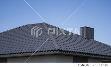 Brown corrugated metal profile roof installed on a modern house. The roof of corrugated sheet. Roofing of metal profile wavy shape. Modern roof made of metal. Metal roofing. Brown corrugated metal profile roof installed on a modern house. The roof of corrugated sheet. Roofing of metal profile wavy shape. Modern roof made of metal. Metal roofing. 78074640
