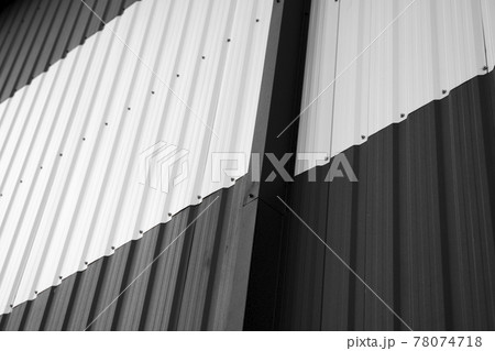 Details of black and white corrugated iron sheet used as a facade of a warehouse or factory. Texture of a seamless corrugated zinc sheet metal aluminum facade. Architecture. Metal texture. 78074718