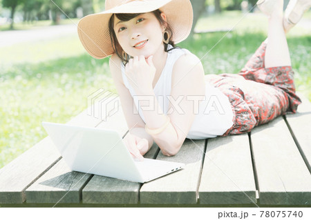 新緑の中でワーケーションをする若い女性 78075740