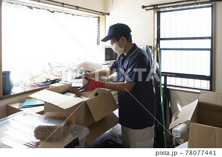 散らかった部屋の片付けをする男性作業員 散らかった部屋の片付けをする男性作業員 78077441