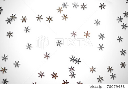 small shiny silver snowflakes on a gray background 78079488