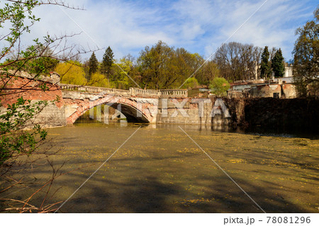 Old arched brick bridge across a pond in Sharovka Palace park in in Kharkov region, Ukraine 78081296
