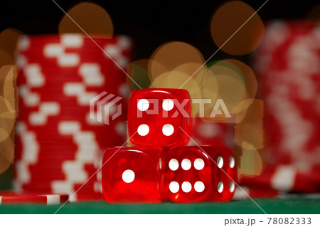 Three red dice against blurred bokeh background 78082333